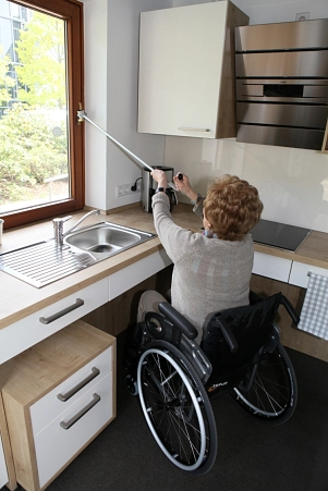 Rollstuhlfahrerin öffnet Fenster mit Fensteröffner